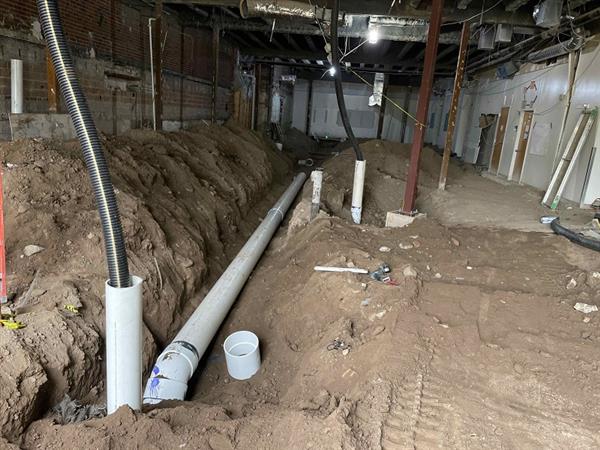 Underground plumbing being installed in new restroom area